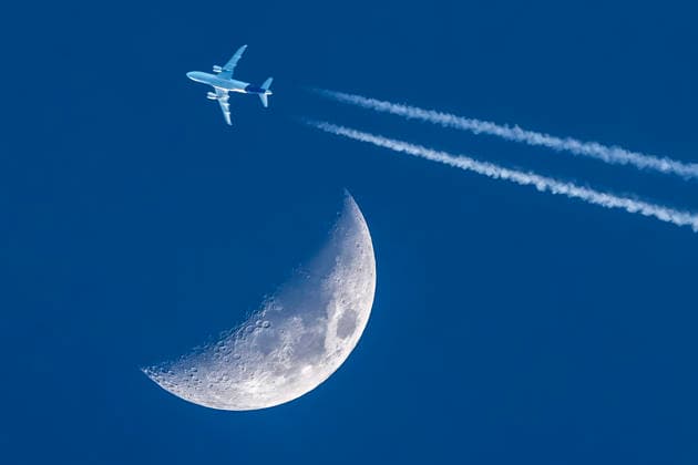 Verkehrsflugzeug fliegt am Mond vorbei, abends um 18:12 Uhr über München, tiefblauer Abendhimmel, 24. März 2026 Deutschland, München, 24. März 2026, Verkehrsflugzeug fliegt am Mond vorbei, zieht Kondensstreifen über den wolkenlosen tiefblauen Himmel, Dienstagabend um 18:12 Uhr bei einsetzender Dämmerung, zweistrahlige Linienmaschine, Flugverkehr, Himmel über München, Frühling, Bayern *** Commercial airplane flies past the moon, in the evening at 18 12 oclock over Munich, deep blue evening sky, 24 March 2026 Germany, Munich, 24 March 2026, commercial airplane flies past the moon, draws contrails over the cloudless deep blue sky, Tuesday evening at 18 12 oclock at the beginning of twilight, twin-jet airliner, air traffic, sky over M