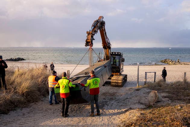 Ein Schwimmbagger wird mit einem Tieflader antransportiert und am Strand mit seinen Pontons verbunden. Buckelwal strandet vor Niendorfer Hafeneinfahrt (Timmendorfer Strand), 25.03.26 Timmendorfer Strand Schleswig-Holstein Germany *** A floating dredger is transported on a low-loader and connected to its pontoons on the beach Humpback whale stranded off Niendorf harbor entrance Timmendorfer Strand , 25 03 26 Timmendorfer Strand Schleswig Holstein Germany Copyright: xAgentur54GradÂ°x xFelixxKoenigx