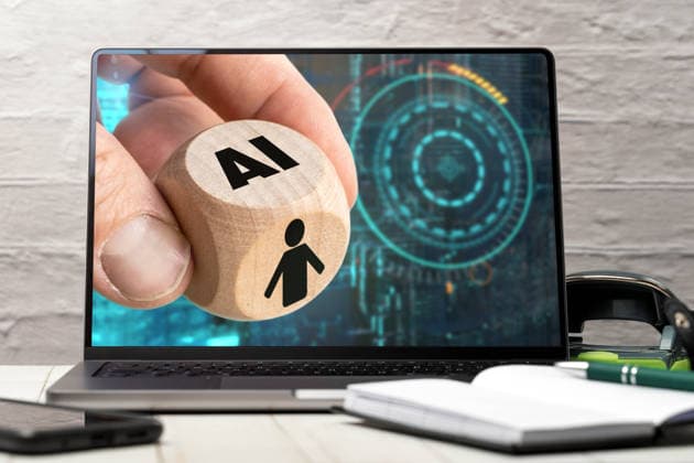 Bavaria, Germany - March 26, 2026: PHOTOMONTAGE, A hand holds a cube labeled AI? in front of a laptop screen, symbolizing artificial intelligence. The image represents technological advancement, automation, and the impact of AI on society and the workplace. *** FOTOMONTAGE, Eine Hand hält einen Würfel mit der Aufschrift AI vor einem Laptopbildschirm und symbolisiert künstliche Intelligenz. Das Bild steht für technologische Entwicklung, Automatisierung und den Einfluss von KI auf Gesellschaft und Arbeit.