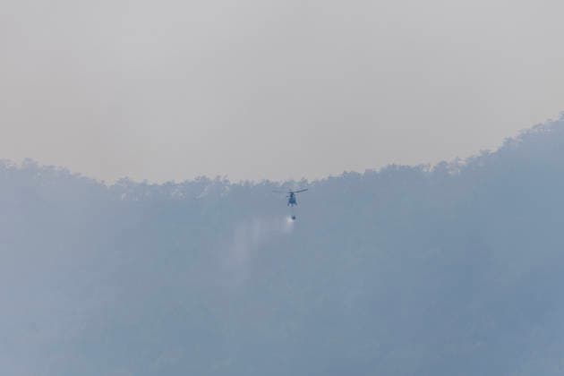 March 27, 2026, Chiang Mai, Thailand: An AS350 helicopter from the Ministry of Natural Resources and Environment conducts aerial firefighting operations over mountainous forest areas in Chiang Mai, northern Thailand, carrying a water bucket while flying through smoke-filled valleys as authorities battle ongoing wildfires and severe PM2.5 air pollution. Chiang Mai Thailand - ZUMAs197 20260327_aaa_s197_368 Copyright: xPongmanatxTasirix