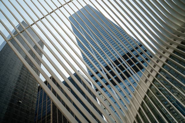 Creative Highlights World Moderner Glaswolkenkratzer, eingerahmt von weißen architektonischen Balken in New York City A tall modern glass skyscraper rises into the sky framed by white architectural beams in New York City. The urban perspective highlights financial district architecture and contemporary city design. (License=RF) Copyright: xZoonar.com DenysxKovtunx 24852650