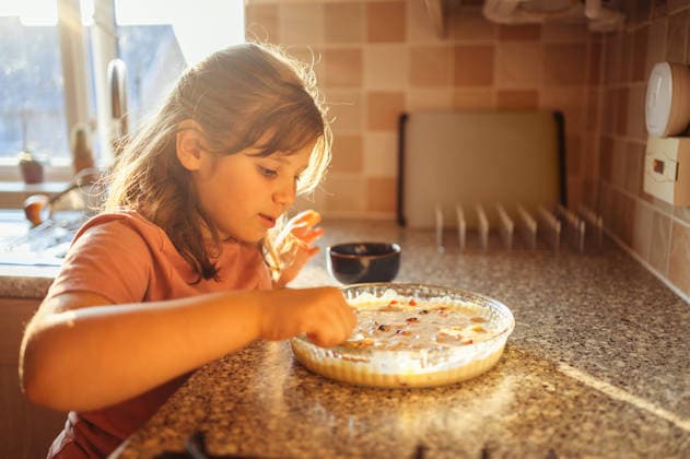 Girl spreading fruits on dough in kitchen, child cooking fruit pie. Corby, England, United Kingdom CR_JNDO260328-1931394-01 ,model released, Symbolfoto