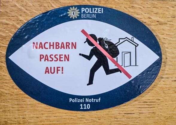 Aufkleber an einer Tür zur Abwehr von Einbrechern, Nachbarn passen auf, Berlin, Deutschland *** Sticker on a door to ward off burglars, neighbors watch out, Berlin, Germany