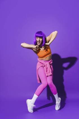 Sorglose junge Tänzerin in bunter Sportkleidung tritt vor lila Hintergrund auf Carefree young woman dancer wearing colorful sportswear performing against purple background Copyright: imageBROKER AnatolijsxJascuks ibxiqx16997016.jpg ,model released, Symbolfoto ,property released