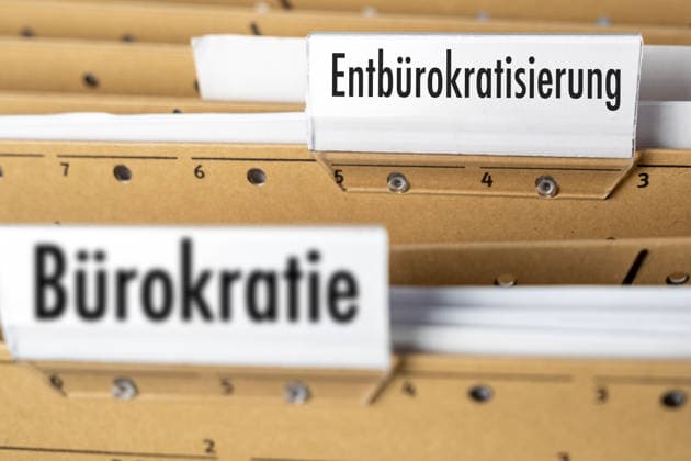 Bavaria, Germany March 31, 2026: PHOTOMONTAGE: A filing cabinet labeled Debureaucratization? with the keyword Bureaucracy? in the foreground symbolizes the political debate in Germany regarding the reduction of administrative burdens, faster procedures, and more efficient government structures. *** FOTOMONTAGE, Ein Karteikasten mit dem Eintrag Entbürokratisierung und dem Stichwort Bürokratie im Vordergrund steht für die politische Diskussion in Deutschland über den Abbau von Verwaltungsaufwand, schnellere Verfahren und effizientere staatliche Strukturen.