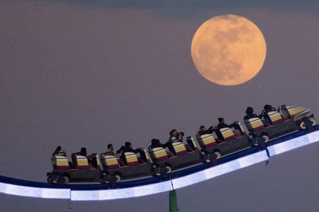 April 1, 2026, Frankfurt, Hesse, Germany: People ride a roller coaster as the April full moon, known as the Pink Moon , rises in Frankfurt, Germany. Frankfurt Germany  - ZUMAb332 20260401_zip_b332_011 Copyright: xMatiasxBasualdox
