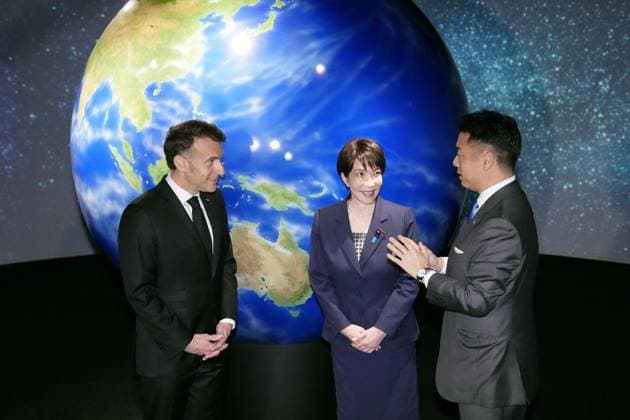 Macron in Tokyo Japanese Prime Minister Sanae Takaichi (C) and French President Emmanuel Macron (L) speak with Nobu Okada, president and CEO of Astroscale Holdings Inc., a Tokyo-based space company working on space debris removal in collaboration with French firms, in Tokyo on April 2, 2026. The visit came after the leaders reaffirmed their commitment to broad cooperation in the space sector during their first in-person summit the previous day.  A14AA0005432385P