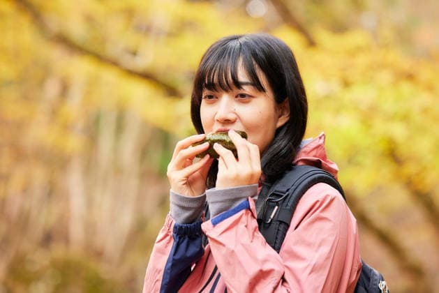 IMAGO Creative, Food, Japan, Onigiri Young Japanese woman refueling with a rice ball on an autumn hike AFLO316841519  316841519 ,model released, Symbolfoto