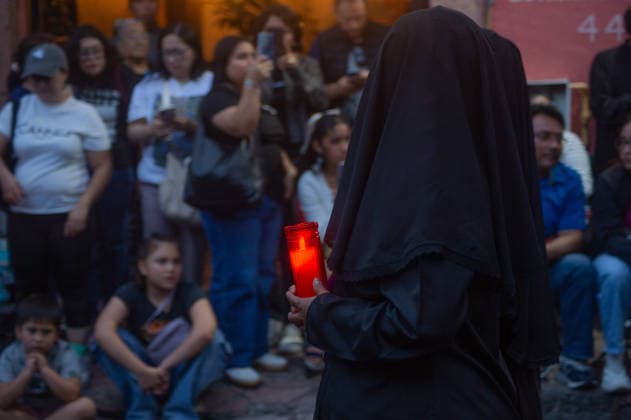 A woman penitent holds a candle and takes a vow of silence as taking part during the procession of silence for Holy Week celebrations in Temple of Santa Cruz, celebrating 60 years of tradition. As Easter approaches, honors one of the solemn religious traditions, the funeral march, know as Silence Procession. on April 3, 2026 in Queretaro, Mexico. Queretaro Mexico  - ZUMAe321 20260403_zia_e321_117 Copyright: xJosexCarrerax