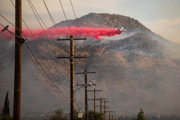 April 3, 2026, Moreno Valley, California, USA: A Coulson C-130 tanker drops flame retardant on a hill by Lake Perris during the Springs Fire on Friday, April 3, 2026 in Moreno Valley, California. Moreno Valley USA  - ZUMAh206 20260403_znp_h206_002 Copyright: xBenjaminxHansonx