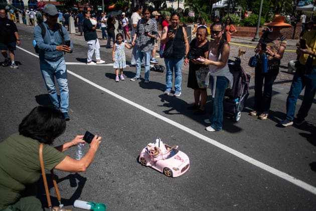 April 4, 2026, Los Angeles, California, USA: People gather and take photographs of a small dog in a remote controlled car during the yearly Blessing of the Animals at Olvera Street on Saturday, April 4, 2026 in Los Angeles, California. Los Angeles USA - ZUMAh206 20260404_znp_h206_007 Copyright: xBenjaminxHansonx