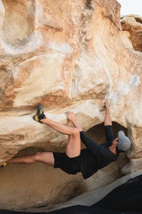 Climber reaching on overhang boulder in Joshua Tree desert Joshua Tree, California, United States CR_AKAO260401B-1972969-01 ,model released, Symbolfoto