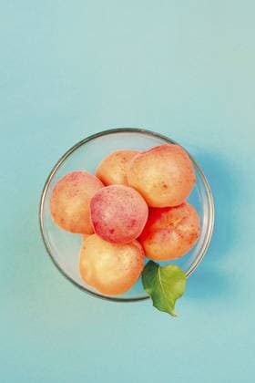 Frische Aprikosen, direkt vom Baum im Garten gepflückt, in einer Schale auf schlichtem blauem Hintergrund Fresh apricots picked straight from tree in the garden in bowl on plain blue background Copyright: imageBROKER PrzemekxKlos ibxiqx16932990.jpg ,model released, Symbolfoto ,property released