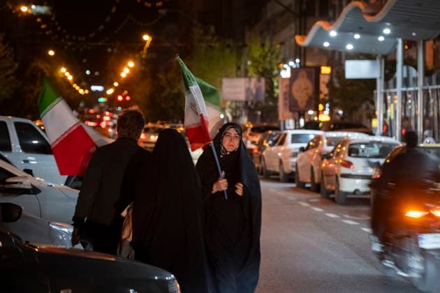 Rally In Support War Against U.S. And Israel A veiled pro-government demonstrator carrying a national flag walks along an avenue after participating in a rally in support of the war against the United States and Israel, in downtown Tehran, Iran, on April 6, 2026, amid ongoing U.S.-Israeli military operations in the country. President Donald Trump threatens the Islamic Republic, stating that if the IRGC does not reopen the Strait of Hormuz within the next 24 hours, he will target Iran s bridges and energy infrastructure. Tehran Tehran Iran  Copyright: xMortezaxNikoubazlx originalFilename: nikoubazl-rallyins260406_npHyl.jpg