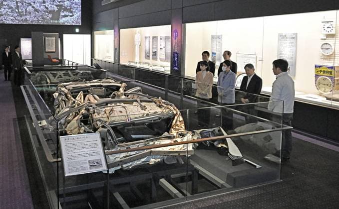 Japan imperial family s trip to Fukushima Japan s Emperor Naruhito (2nd from R), Empress Masako and their daughter Princess Aiko visit the Historical Archive Museum of Tomioka in Tomioka, Fukushima Prefecture, on April 7, 2026. The imperial family is visiting Fukushima Prefecture to observe the recovery efforts after a massive earthquake and tsunami struck the region in March 2011, triggering a nuclear accident at the Fukushima Daiichi power plant. Seen in the front is a police car wrecked in the tsunami.  A14AA0005440886P