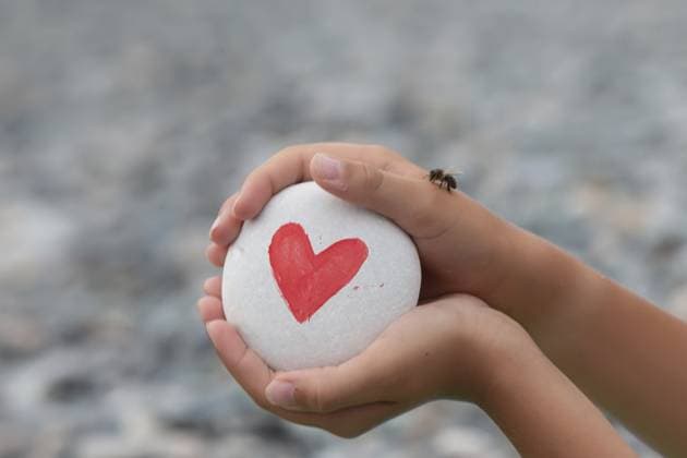 Die Hände des Kindes halten einen weißen Stein, auf dem ein rotes Herz gezeichnet ist The child s hands hold a white stone with a red heart drawn on it Copyright: imageBROKER Svetlana ibxiqx17101693.jpg ,model released, Symbolfoto ,property released