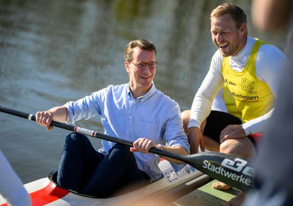 Ministerpräsident Hendrik Wüst (NRW) sitzt in einem Ruderboot und hält ein Rudern in der Hand, daneben Kanu Olympiasieger Max Rendschmidt r. Ministerpräsident Hendrik Wüst (NRW) besucht das Bundesleistungszentrum Kanusport, am 07.04.2026 in Duisburg Deutschland. Bundesleistungszentrum Kanusport *** Minister President Hendrik Wüst NRW sits in a rowing boat and holds an oar in his hand, next to canoe Olympic champion Max Rendschmidt r Minister President Hendrik Wüst NRW visits the Federal Canoeing Performance Center, on 07 04 2026 in Duisburg Germany Federal Canoeing Performance Center