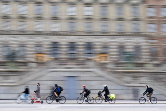 April 7, 2026, Stockholm, Stockholm, Sweden: People on bicycles and scooters ride past the Royal Palace in Stockholm, Sweden. Stockholm Sweden - ZUMAb332 20260407_zip_b332_028 Copyright: xMatiasxBasualdox