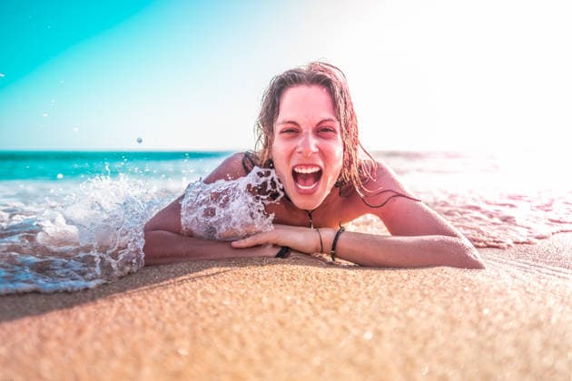 Caucasian young woman lying on the beach laughing Cádiz, AL, Spain R_ANOL201027-541457-01 ,model released, Symbolfoto