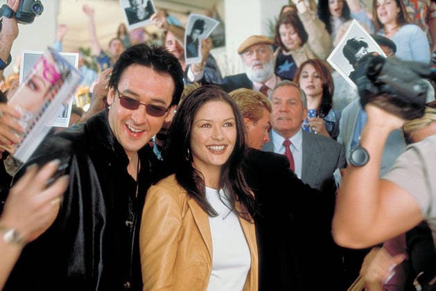 2001 - America s Sweethearts - Movie Set RELEASE DATE: July 20, 2001. MOVIE TITLE: America s Sweethearts. STUDIO: Revolution Studios. PLOT: In the midst of a nasty public breakup of married movie stars, a studio publicist scrambles to put a cap on the escalating situation as the couple s latest film has found it s only print kidnapped by the director. PICTURED: JOHN CUSACK as Eddie Thomas and CATHERINE ZETA-JONES as Gwen Harrison. Los Angeles California U.S. Copyright: xRevolutionxStudiosx