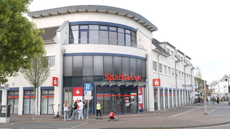 Die Eingangsfassade einer Sparkasse mit mehreren wartenden Personen davor. Rommerskirchen, 09.04.2026. Nordrhein-Westfalen Deutschland *** The entrance facade of a savings bank with several people waiting in front of it Rommerskirchen, 09 04 2026 Nordrhein Westfalen Germany