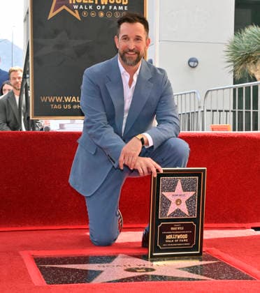 American actor, director and writer Noah Wyle kneels next to his star during an unveiling ceremony honoring him with the 2,840th star on the Hollywood Walk of Fame in Los Angeles on Thursday, April 9, 2026.  LAP20260409909 JIMxRUYMEN