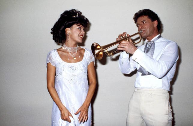 Schauspielerin Anja Kruse, in festlichem Outfit, mit Partner Heinz Hellberg, Wiener Operettensänger und Musicaldarsteller, hier bringt Heinz Hellberg seiner Anja mit der Trompete ein Ständchen, circa 1987. Copyright: HartwigxValdmanis Nur redaktionelle Nutzung. Editorial usage only. VAL_7205005517
