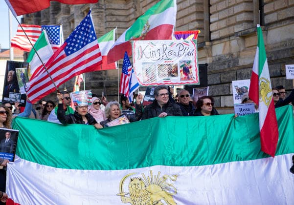 News Bilder des Tages April 11, 2026, Leipzig, Saxony, Germany: A small group of demonstrators gathers in Leipzig, assembling in front of the U.S. Consulate General Leipzig. The crowd holds a wide historic Iranian tricolor flag with the lion-and-sun emblem stretched across the front, while others wave both Iranian and American flags above their heads. Several participants carry posters and placards, including images and messages referencing Reza Pahlavi and calls for political change in Iran. Leipzig Germany  - ZUMAc291 20260411_zip_c291_002 Copyright: xMariaxCastrox