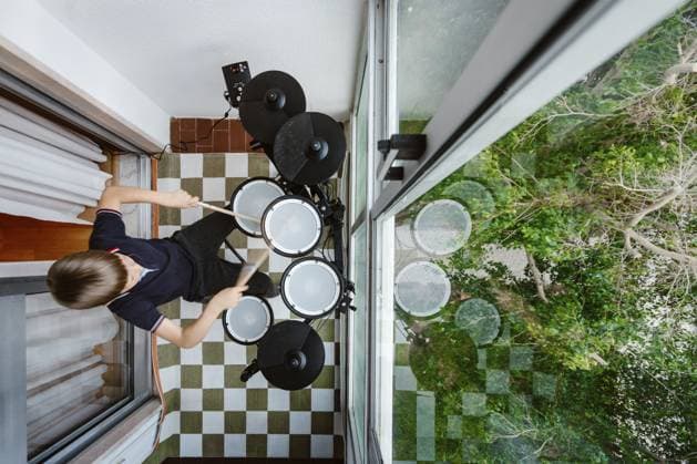 Junge spielt zu Hause elektronisches Schlagzeug auf dem Balkon, Kind übt Musik Boy playing electronic drums on balcony at home, child practicing music Copyright: imageBROKER EunikaxSopotnicka ibxeso17233015.jpg ,model released, Symbolfoto ,property released