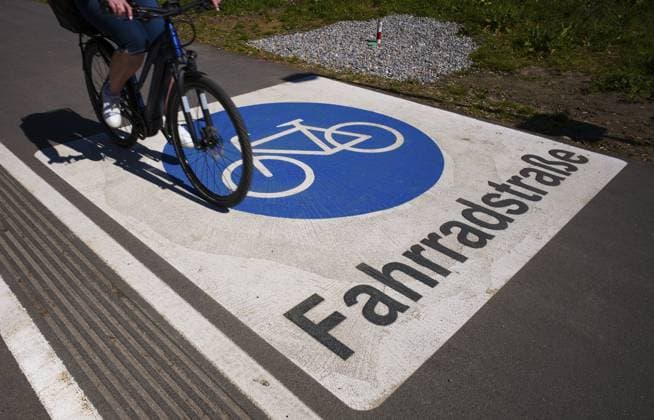 Radfahrer, Fahrradfahrer, fährt über Markierung, Kennzeichnung, Verkehrszeichen Fahrradstraße, Fahrradstrasse, Logo, auf Asphalt einer Straße, Lochau, Vorarlberg, Bodensee, Österreich Cyclists, cyclists, driving over markings, traffic signs bicycle road, bicycle road, logo, on asphalt of a road, Lochau, Vorarlberg, Lake Constance, Austria Copyright: imageBROKER MichaelxWeber ibximw17308816.jpg