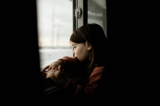 Young Caucasian girl looking out of a window in a dark room Calgary, Alberta, Canada CR_AMST26041009-1892966-01 ,model released, Symbolfoto ,property released
