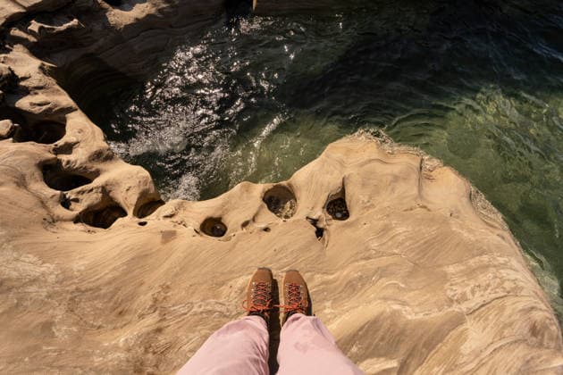 Person s feet wearing hiking boots and pink pants on sandstone rock Munising, Michigan, United States CR_MCKJ260411-1975771-01 ,model released, Symbolfoto
