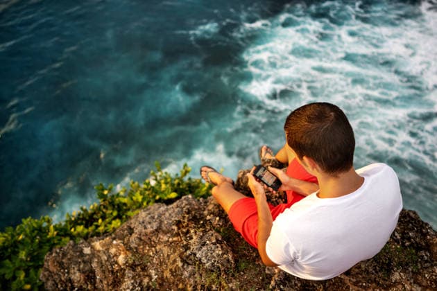 A guy sits on a cliff in Bali. Kuta Selatan, Bali, Indonesia CR_NAOS260410-1992542-01 ,model released, Symbolfoto