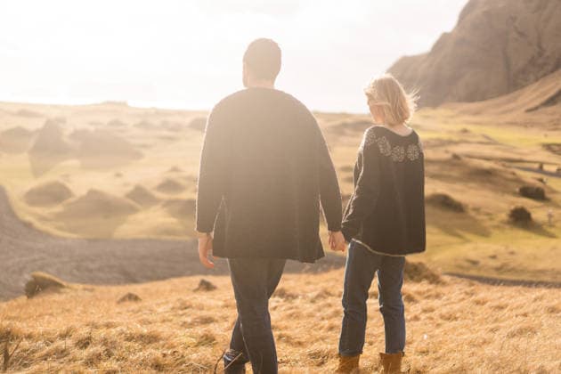 A loving couple walks in the mountains wearing Icelandic sweaters. Vestmannaeyjabær, Vestmannaeyjabær, Iceland CR_NAOS260410-1992586-01 ,model released, Symbolfoto