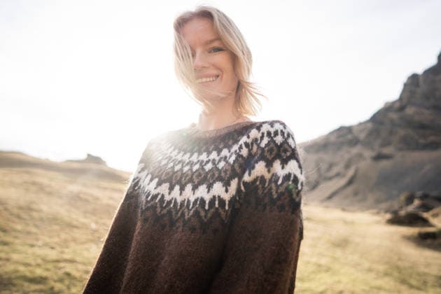 A girl wearing an Icelandic sweater stands on an island Vestmannaeyjabær, Vestmannaeyjabær, Iceland CR_NAOS260410-1992618-01 ,model released, Symbolfoto