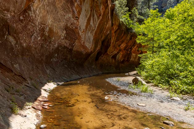 Creative Highlights World Shallow waterway under rock cliff overhang in wilderness Sedona, Arizona, United States R_MALI260413A-1998584-01