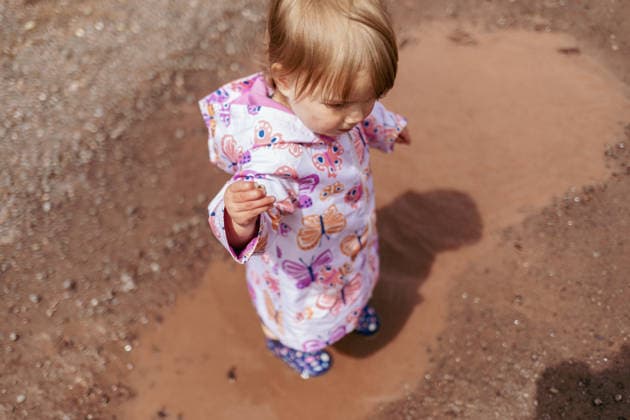 Child splashing in spring rain puddle Painesdale, Michigan, United States R_OAXI260410A-1978273-01 ,model released, Symbolfoto