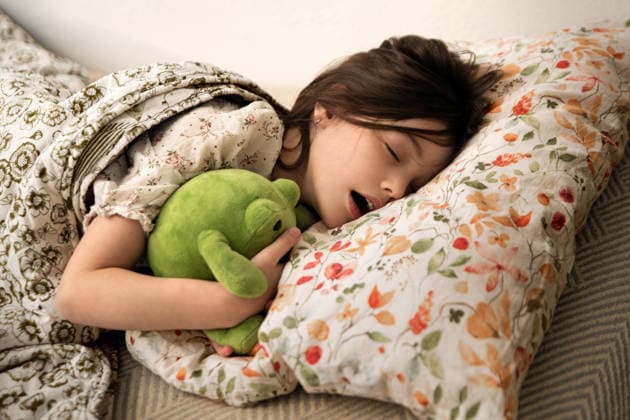 Kid girl sleeping in bed with plush frog toy. on floral pillow Saint Petersburg, Saint Petersburg, Russia R_YFCG26041006-1995714-01 ,model released, Symbolfoto