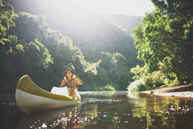 Travel, kayak and smile with woman in lake for forest adventure, journey or eco tourism. Wildlife expedition, canoe boat and weekend break with person rowing in nature for summer vacation and explore. model released property released Copyright: xROWANxJORDAN(PTY)LTDx