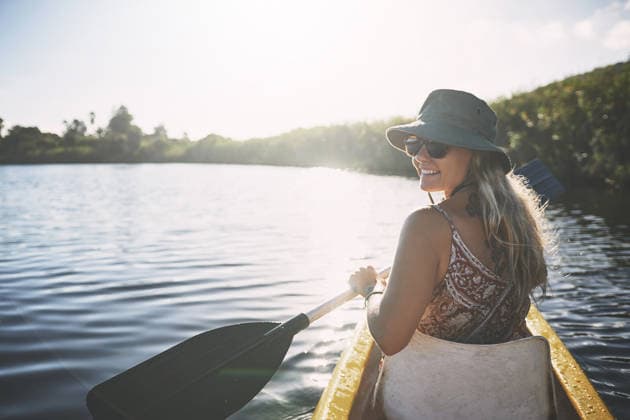 Canoe, happy and woman in nature for lake, summer vacation and adventure on holiday in countryside. Female person, rowing journey and smile on boat with paddle on river for travel and space outdoor. model released property released Copyright: xROWANxJORDAN(PTY)LTDx