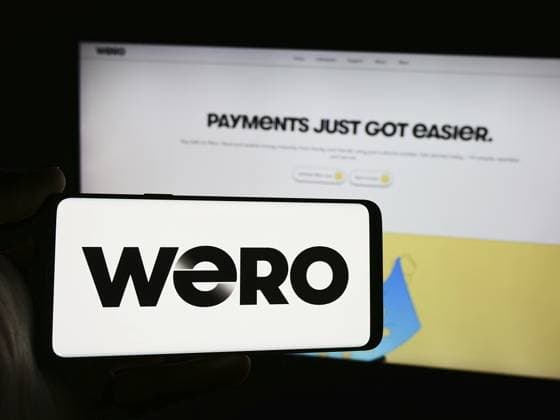 Stuttgart, Deutschland 31.07.2024: Person, die ein Handy mit dem Logo des europäischen mobilen Zahlungssystems Wero vor der Geschäftswebseite hält. Konzentrieren Sie sich auf das Telefondisplay Stuttgart, Germany - 07-31-2024: Person holding mobile phone with logo of European mobile payment system Wero in front of business web page. Focus on phone display Copyright: imageBROKER TimonxSchneider ibliqx17114763.jpg