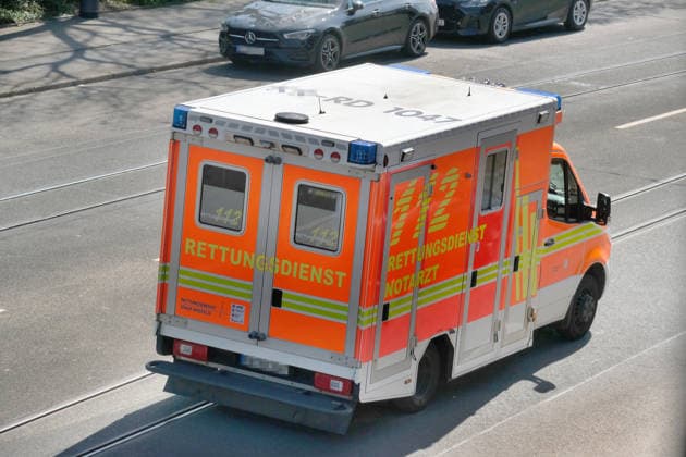 Rettungswagen faehrt ueber eine Stadtstrasse Szene einer Rettungsaktion am Rettungswagen *** Ambulance driving along a city street Scene of a rescue operation at the ambulance