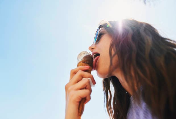 Woman eating ice cream on summer vacation. Low angle of girl having treat on beach. (License=RF) ,model released, Symbolfoto  Copyright: xZoonar.com KasperxRavlox 18806762 ,model released, Symbolfoto ,property released