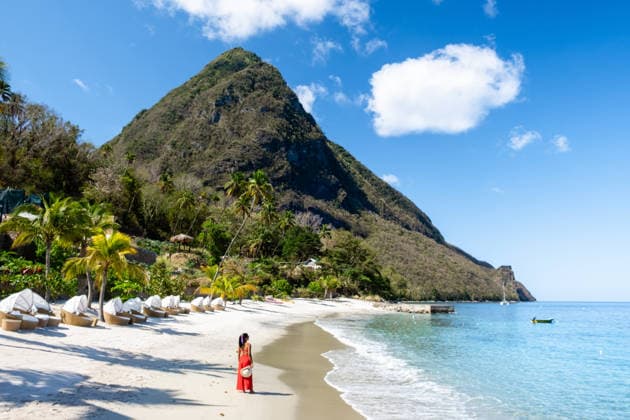 Ein tropisches Paradies auf St. Lucia mit atemberaubenden Bergen und entspannter Strandatmosphäre Basking in the warm sun, a traveler enjoys the breathtaking views of Saint Lucia coastline. Asian women in red dresses walking on the beach during a luxury vacation in the Caribbean (License=RF) ,model released, Symbolfoto Copyright: xZoonar.com FokkexBaarssenx 24862532 ,model released, Symbolfoto ,property released