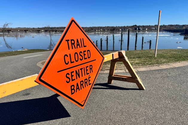 April 21, 2026, Fredericton, Nb, CANADA: Signage is seen by the Carleton Street River Lookout as rising water levels of the Saint John River closed trails this week, in Fredericton, Tuesday, April 21, 2026. Fredericton CANADA  - ZUMAc35_ 20260421_zaf_c35_039 Copyright: xElixRidderx
