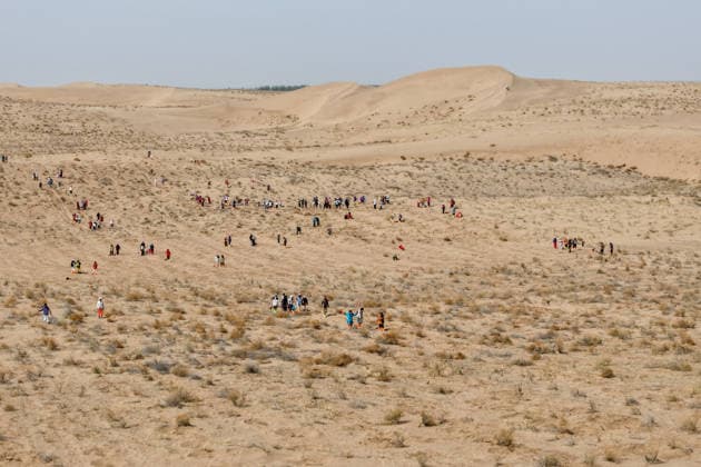 (260422) -- MINQIN, April 22, 2026 -- A drone photo shows volunteers planting trees at the Zhonglin ecological public welfare forest base of Minqin County, northwest China s Gansu Province, April 21, 2026. Minqin, sandwiched between China s third- and fourth-largest deserts -- the Badain Jaran and the Tengger, has 94 percent of its land area covered by desert and desertified land. As a result, it is one of China s major sources of sandstorms. Confronted with pressing survival challenges and the daunting task of desert control, Minqin County has initiated multiple tree-planting campaigns since 2024. Volunteers from all over China came to the county s Zhonglin ecological public welfare forest base to participate in voluntary tree-plantin 