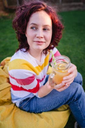 Teen age girl enjoying a lemonade drink on yellow bean bag Corby, England, United Kingdom R_ATMT260410-1991290-01 ,model released, Symbolfoto