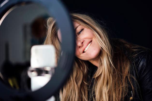 Happy blond mature influencer vlogging through mobile phone model released, Symbolfoto property released, JOSEF24087
