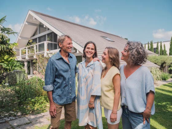 Family standing together and smiling in garden outside modern house model released, Symbolfoto property released, MFF09869