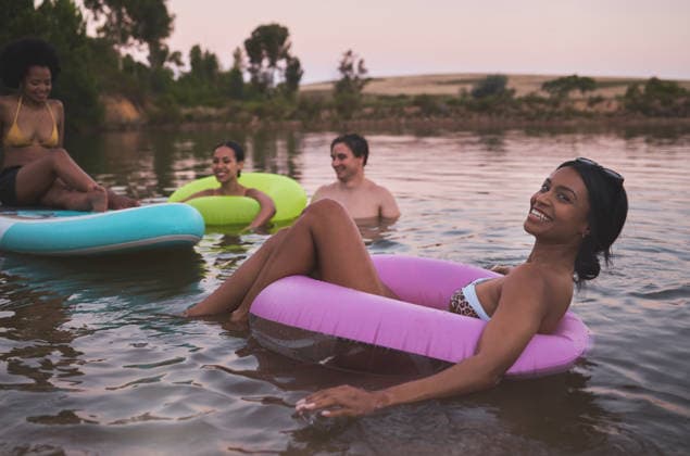 Vacation, swimming and friendship having fun in a lake while enjoying the summer sunset. Happy friends relaxing and floating in water while talking and bonding on a getaway holiday. (License=RF) ,model released, Symbolfoto  Copyright: xZoonar.com YurixArcursxpeopleimages.comx 18993379 ,model released, Symbolfoto ,property released